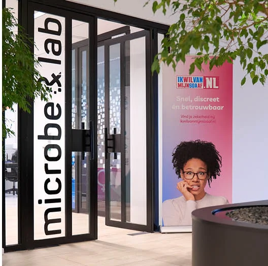 De ingang van het laboratorium waar de ingestuurde monsters worden onderzocht, met een banner van ikwilvanmijnsoaaf.nl ernaast