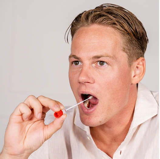 Jonge man neemt zelf een uitstrijk in zijn keel met het afnamestaafje uit de testset